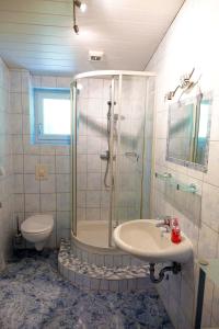 un bagno con doccia, lavandino e WC di Haus Alpengluehn a Iselsberg