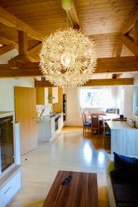 un ampio soggiorno con lampadario e cucina di Haus Alpengluehn a Iselsberg