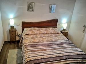 - une chambre avec un grand lit et 2 tables de chevet dans l'établissement Villa Sa Pruna, à Oliena