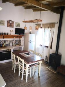 Il comprend une cuisine équipée d'une table, de chaises et d'une cuisinière. dans l'établissement Villa Sa Pruna, à Oliena