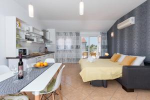 uma cozinha e sala de estar com uma cama e uma mesa em Seafront apartment Gaby em Medulin