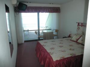 a bedroom with a bed and a view of a balcony at Hotel Riviera in Las Grutas +22 photos