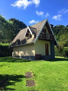 a small house with a green lawn in front of it at Chalé Recanto do Sossego in Gonçalves