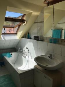 een badkamer met een wastafel en een bad bij Gästewohnung Saaleblick in Weißenfels