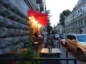 un restaurante con una sombrilla roja en una calle en Mtatsminda, en Tiflis