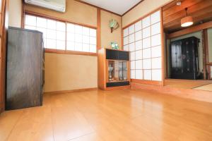 Habitación grande con suelo y ventanas de madera. en Saitama Niiza House / Vacation STAY 4274 en Niiza