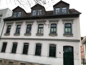a large white building with windows and a green door at Gästewohnung Saaleblick in Weißenfels