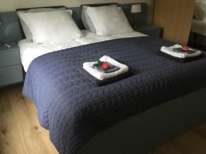 Una cama con dos toallas y dos rosas. en B & B ANNAMIE, en Vlissingen