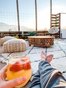 a person holding a glass of drink in their hand at Miracle Manor Boutique Hotel & Spa in Desert Hot Springs