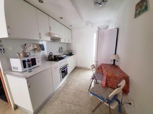 cocina con nevera, mesa y silla en Gutierrez Apartment, en Alicante