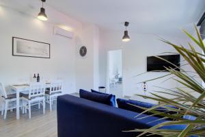 a living room with a blue couch and a table at VisumApartments in Senj
