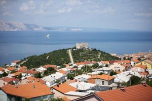 a town with orange roofs and a castle on a hill at VisumApartments in Senj