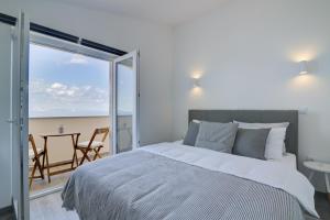 a bedroom with a bed and a view of the beach at VisumApartments in Senj