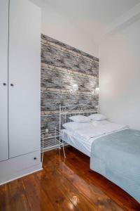 1 dormitorio con 1 cama y pared de madera en Apartamenty Dominikańskie, en Toruń