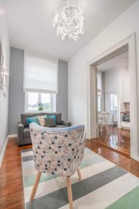 a living room with a chair and a couch at Apartamenty Dominikańskie in Toruń