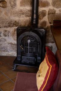 a stone fireplace with a couch in front of it at Casa do Telhado in Guimarães