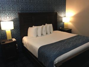 a hotel room with a large bed with two lamps at Riverside inn hannibal in Hannibal
