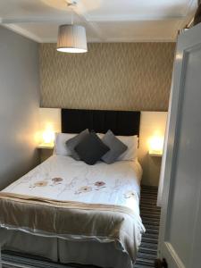 a bedroom with a bed with two lamps on two tables at Mary Ann's Ballyheigue Cottage in Tralee