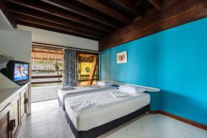 um quarto com 2 camas e uma parede azul em Cispata Marina Hotel em San Antero