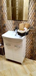 a bathroom with a white sink and a mirror at Апартамент България със свободна зона за паркиране in Veliko Tŭrnovo