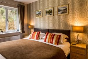 a bedroom with a bed with two pillows and a window at Hermiston Guest House in Keswick