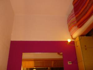Un dormitorio con una pared de acento púrpura y una cama en Ferienwohnung Glockenberg, en Altenau