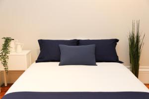 Una cama con almohadas azules encima. en Cozy Furnished Studio in Beacon Hill #4 en Boston