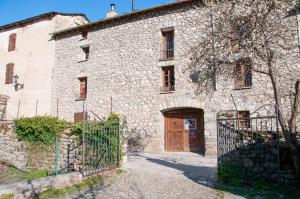 un antiguo edificio de piedra con una puerta y una puerta en Casa Piñana, en Anciles