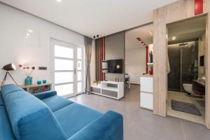 Una sala de estar con un sofá azul y un televisor. en Dalí, en Zadar