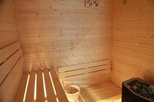 a wooden sauna with a trash can in it at Blue Door Apartment Ground Floor in Augustów