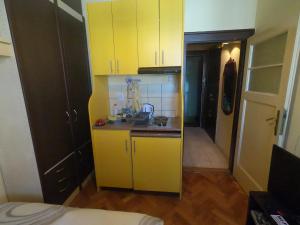 małą kuchnię z żółtymi szafkami w pokoju w obiekcie Aprtman Sonja 2 w Belgradzie
