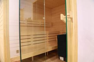 a sauna with a glass shower in a room at Blue Door Apartment in Augustów