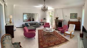 sala de estar con sillas rosas y sofá en VILLA SANTINE AVEC TERRASSES et VUE PANORAMIQUE meublé tourisme 4 étoiles, en Santa-Lucia-di-Tallano