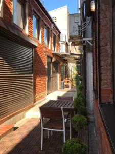 une table et une chaise en bois assises sur une terrasse dans l'établissement Jolie Apartments, à Kaunas