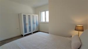 a white bedroom with a bed and a window at ARIA in Sumartin
