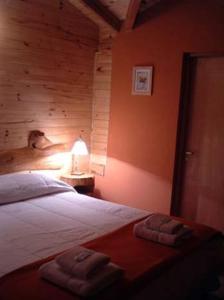 a bedroom with a bed with two towels on it at Cabañas En el Corazón del Bosque in San Carlos de Bariloche