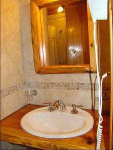 a bathroom with a sink and a mirror at Cabañas En el Corazón del Bosque in San Carlos de Bariloche