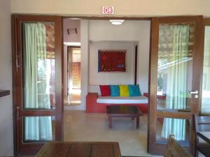 uma sala de estar com um sofá com almofadas coloridas em Baixu Village em Arraial d'Ajuda