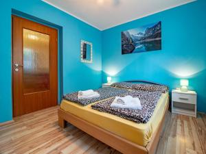a blue bedroom with a bed with towels on it at Apartman Arijana 3 in Medulin