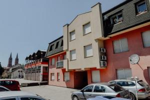 a parking lot with cars parked in front of a building at Apartman M5 in Đakovo