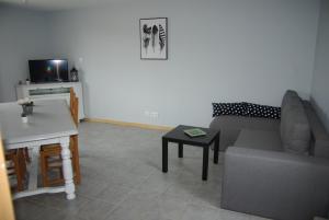 sala de estar con sofá y mesa en GRANGE du BOSQUET en Vendeuvre