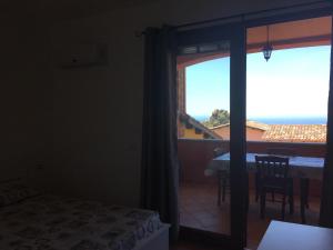a bedroom with a door open to a room with a view at TERRAZZA SUL MARE wifi e piscina in Nebida
