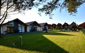 a park with houses and a playground at Domki na Rozanej in Rowy