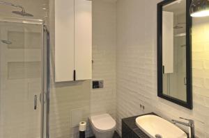 a bathroom with a sink and a toilet and a mirror at Apartament RELAKS w spokojnej okolicy - SUN&SPORT in Szczyrk +4 photos