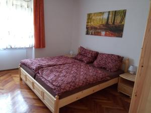 Bochmann Cottage في Zalaszántó: غرفة نوم مع سرير مع لحاف أرجواني