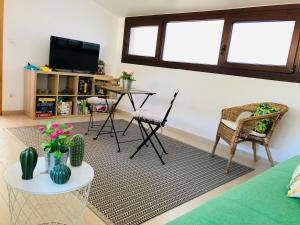 Una sala de estar con una mesa y sillas y un televisor. en CASA A GUARDA, en A Guarda