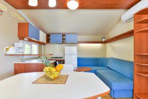 un soggiorno con divano blu e tavolo di Mobile house 5 Laguna a Turanj (Torrette)