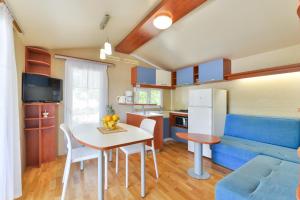 Mobile house 5 Laguna في توراني: مطبخ وغرفة معيشة مع طاولة وأريكة