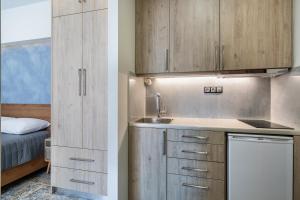 卡尼亞鎮的住宿－Central Cozy Studio，厨房配有木制橱柜、水槽和床。