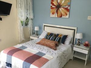 a bedroom with a bed with two night stands and two lamps at Cool Breeze Discovery Bay in Discovery Bay